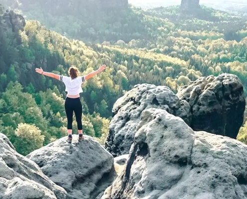 Eine junge Frau steht auf einem Felsen