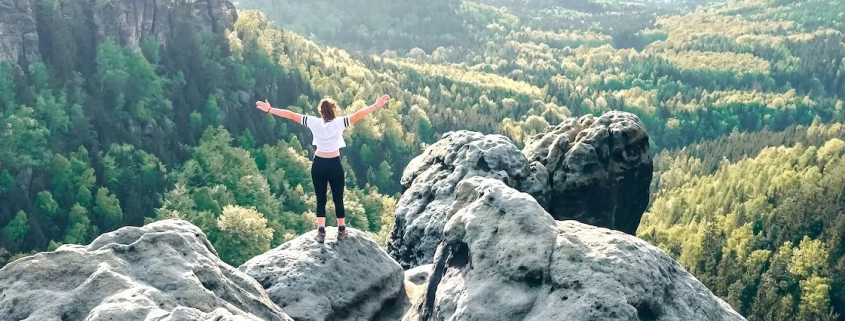 Eine junge Frau steht auf einem Felsen